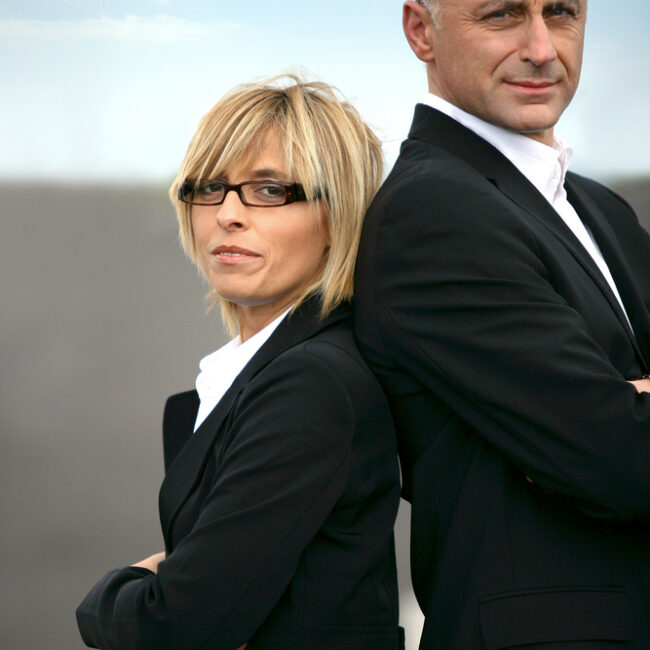 business woman and man standing back to back