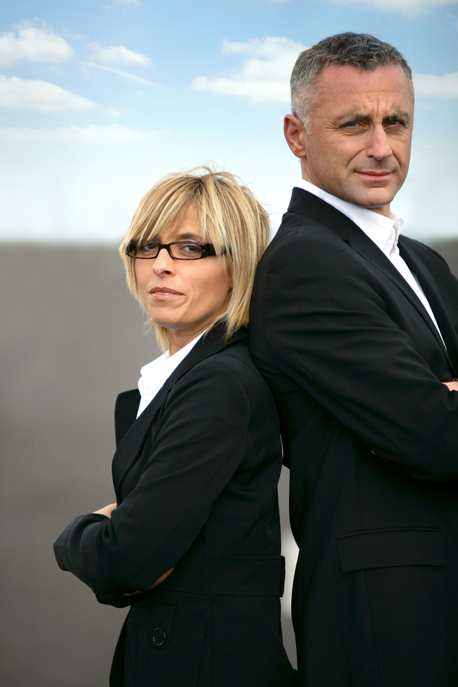 business woman and man standing back to back